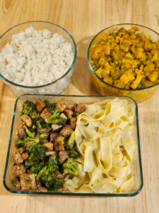 Gourmet meal prep containers featuring vegan vegetable curry in cashew cream, with a side of basmati rice, mushroom-broccoli and tofu stir fry in ginger lemongrass sauce prepared by a private chef.